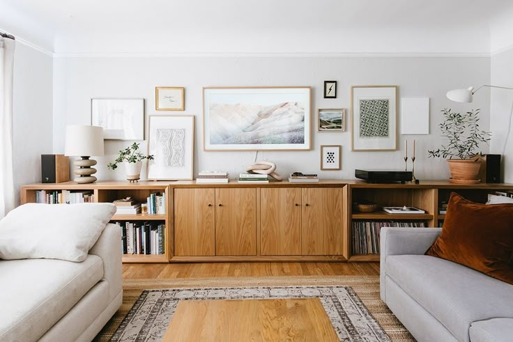 a living room filled with lots of furniture and pictures on the wall above it's bookshelf