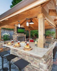 an outdoor kitchen with stone counter tops and grilling area