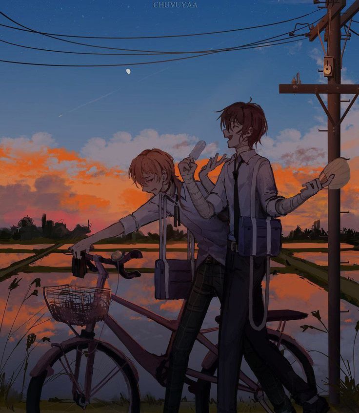 two people standing next to each other in front of a lake with a bike and telephone pole