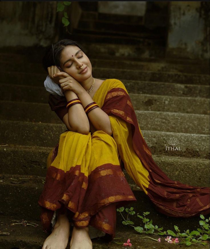 a woman is sitting on the steps with her head in her hands and eyes closed