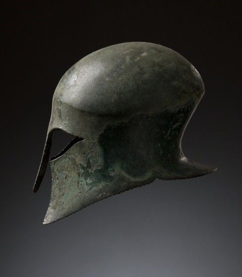 an ancient helmet is being held up in the air