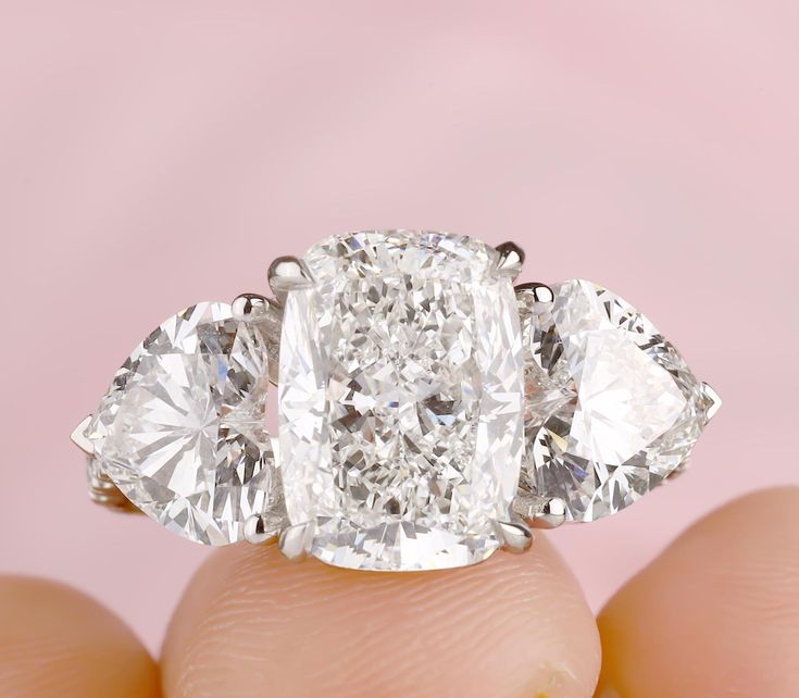 a three stone diamond ring on someone's finger