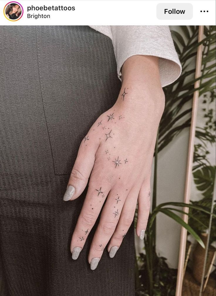 a woman's hand with stars tattooed on it