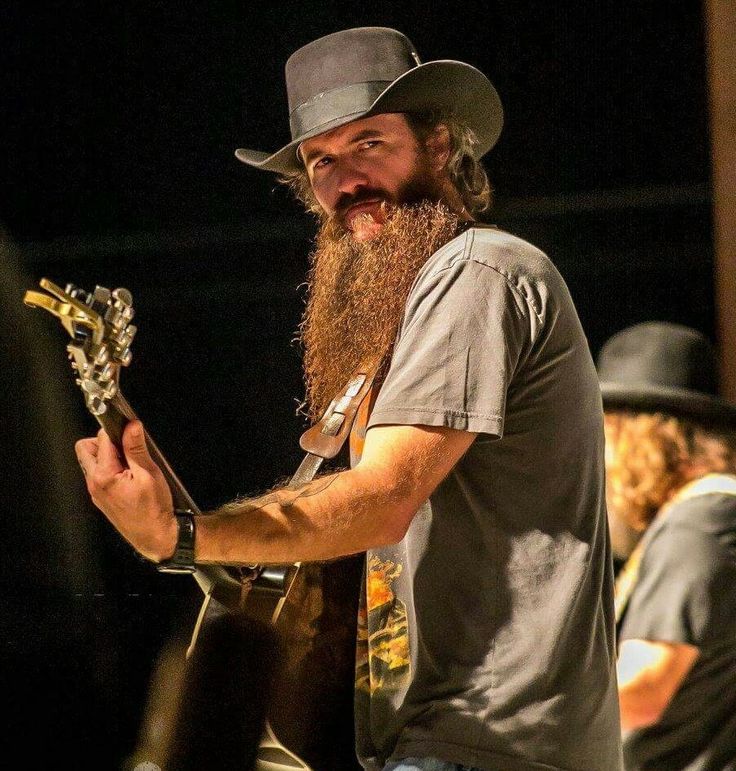 a man with a long beard holding a guitar