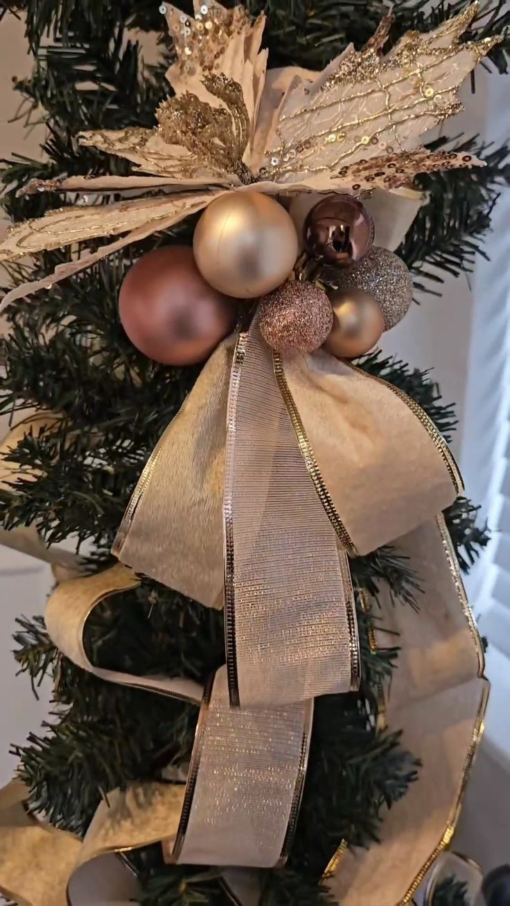 a christmas tree with ornaments hanging from it's sides and ribbons on the top