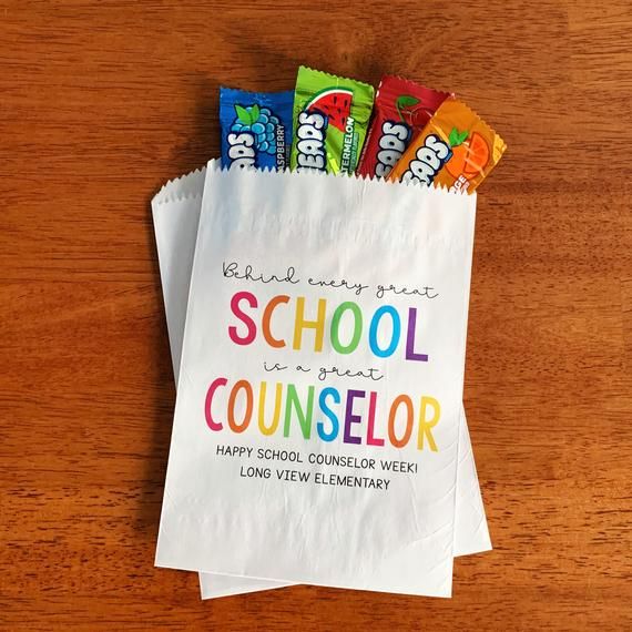 some candy bars are sitting on top of a paper bag that says school is a great counselor