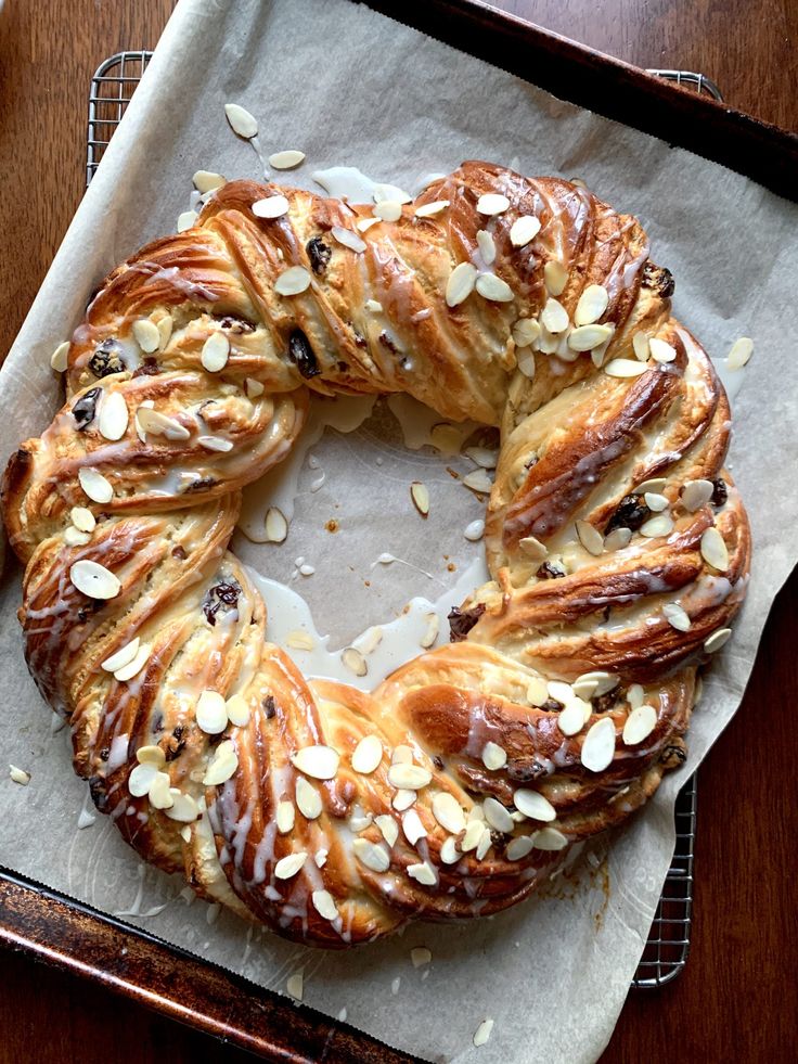 a baked pastry with almonds and raisins is on a tray, ready to be eaten