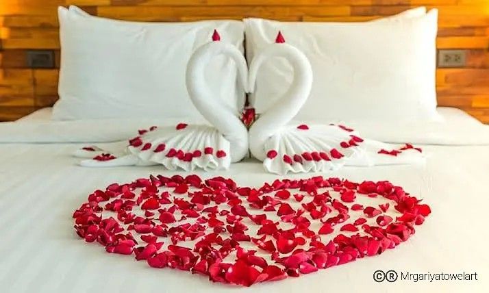 two swans made out of hearts on a bed