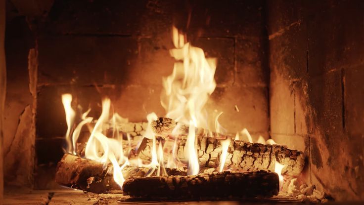 a fire burning in a fireplace with lots of flames