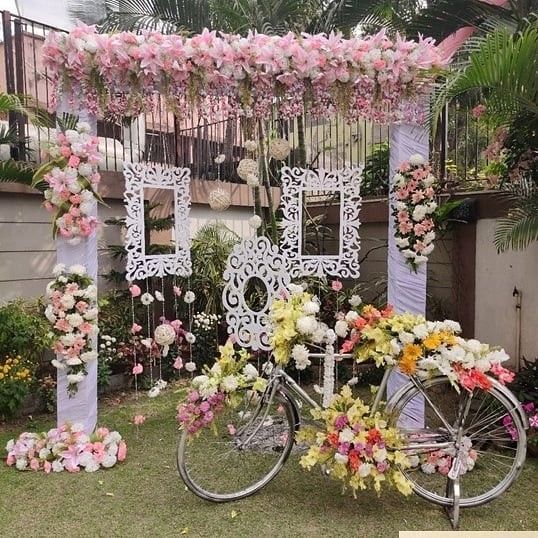 a bicycle with flowers on the back parked in front of a building