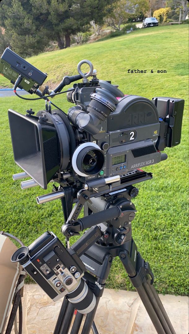 a camera on a tripod outside in the grass