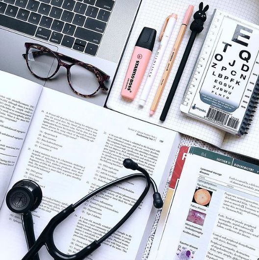 an open book with eye glasses and a stethoscope