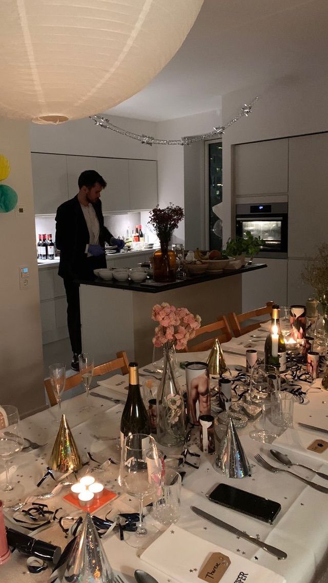 a dining room table is set with wine glasses and bottles, candles, and flowers