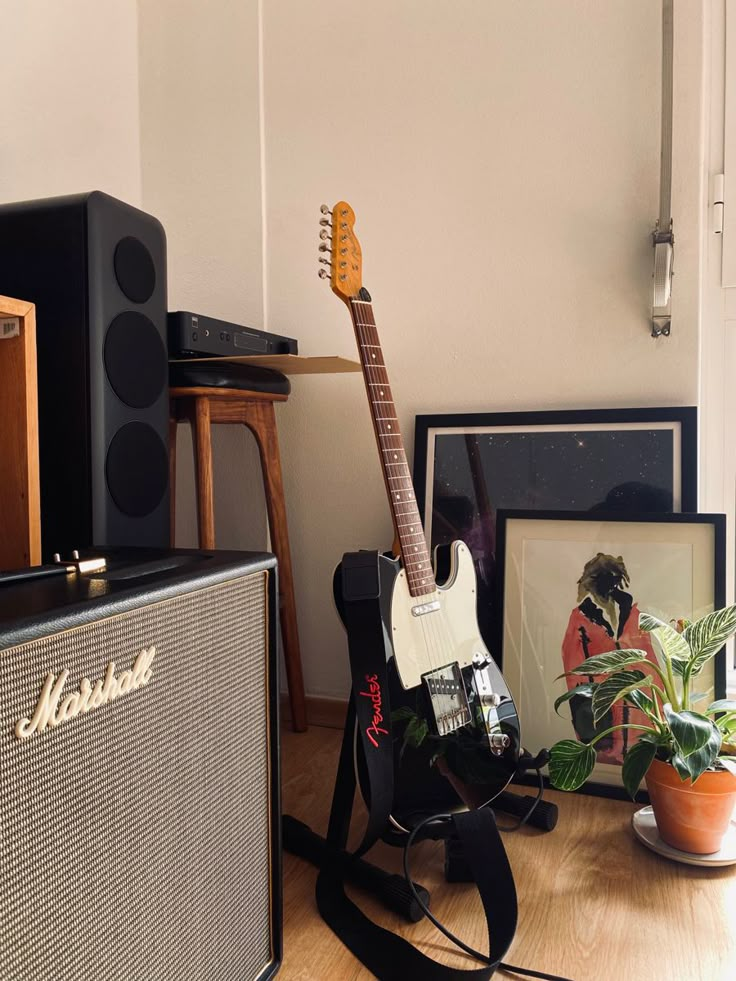 an electric guitar sitting on top of a hard wood floor next to two amps