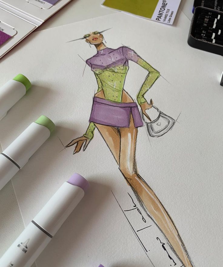 a drawing of a woman's dress and hat on paper with markers next to it