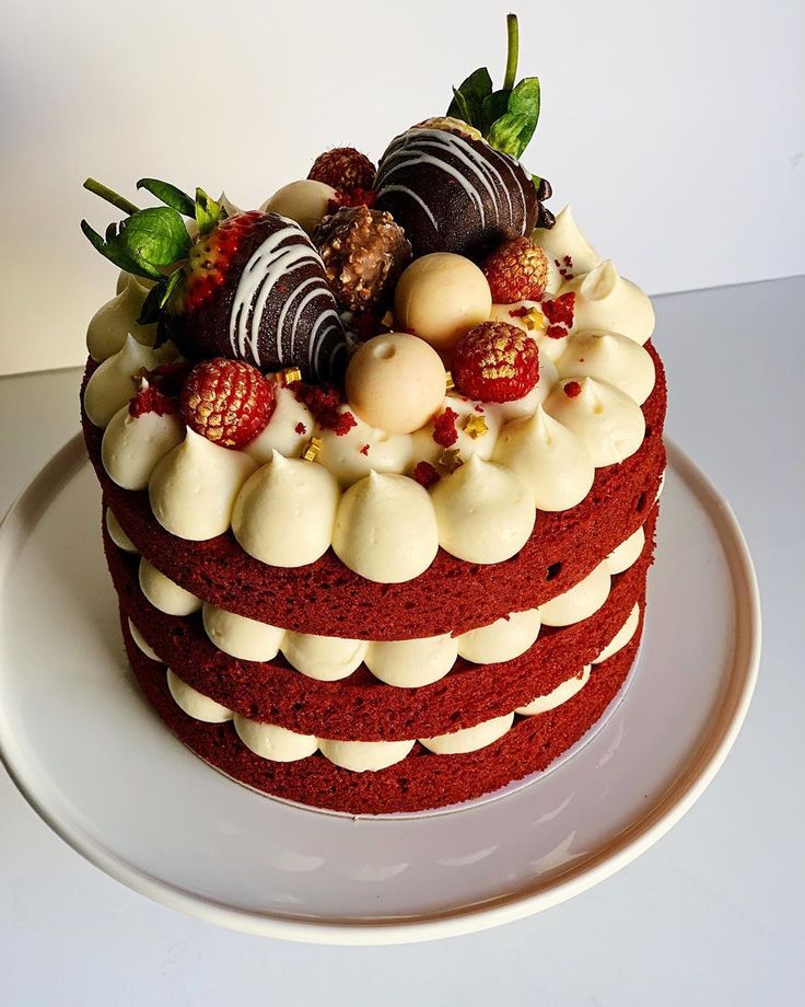 a red velvet cake with white frosting and strawberries on top