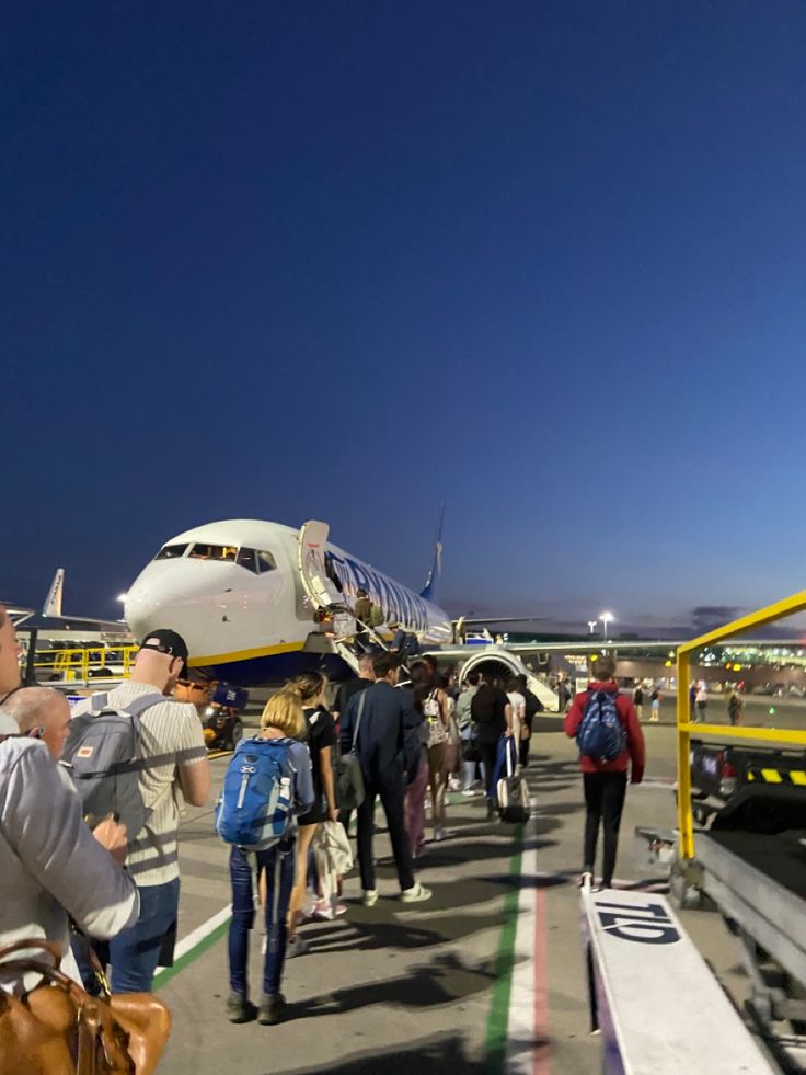 many people are walking towards an airplane on the tarmac