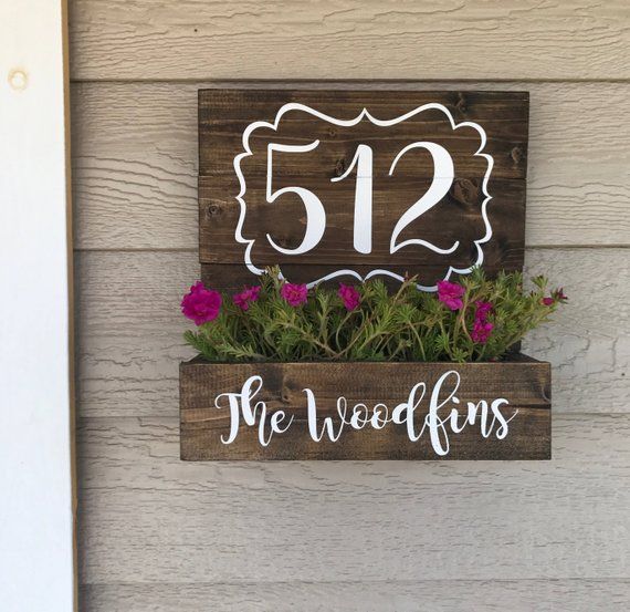 a wooden sign that says, the weedkins is 512 and has flowers in it