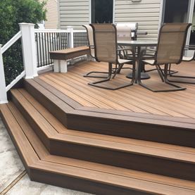 a wooden deck with chairs and table on it