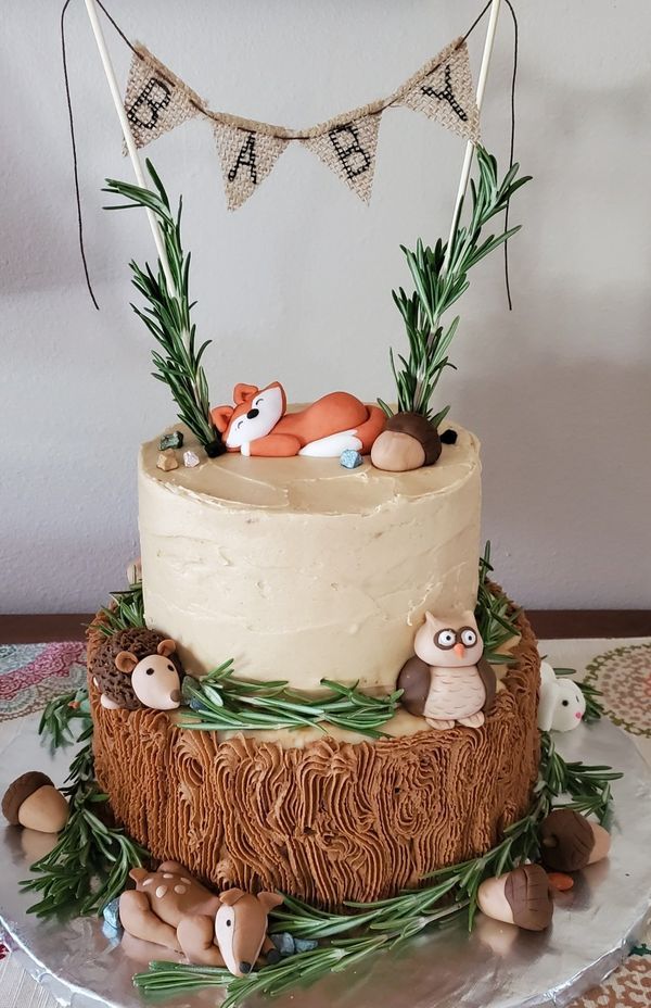 there is a cake that has been decorated with animals and grass on the top tier