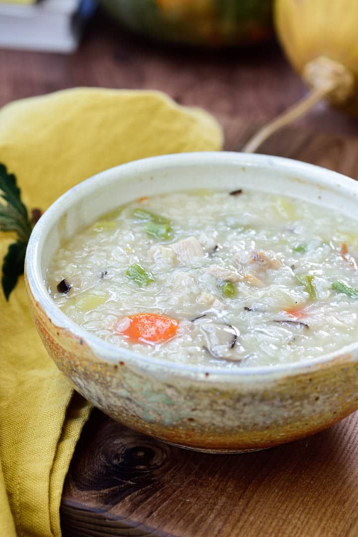 a white bowl filled with soup on top of a wooden table