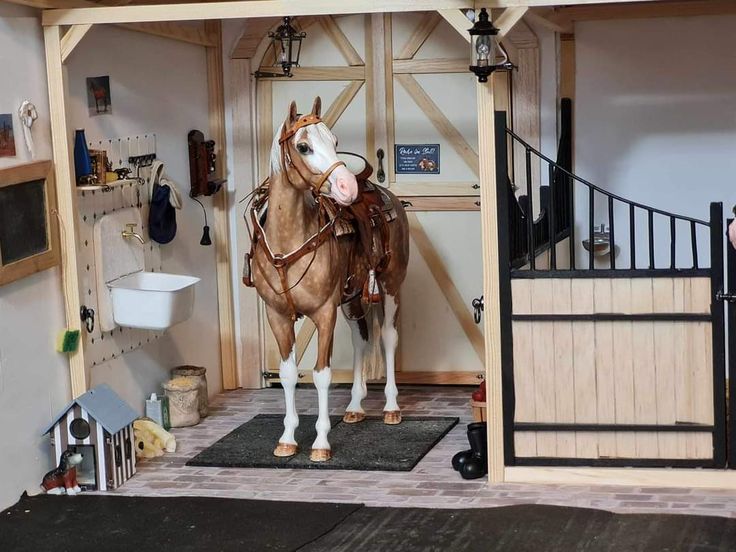 a horse that is standing in the middle of a room next to a fence and door