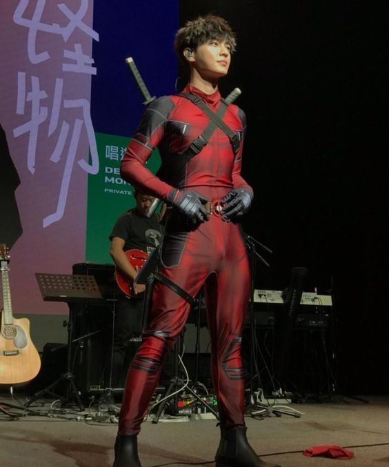 a man in a red and black costume on stage