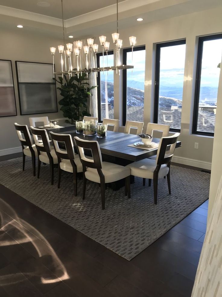 a dining room table and chairs with large windows