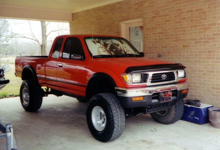 a red truck parked in front of a brick building