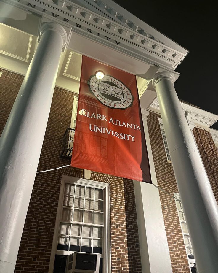 an orange banner hanging from the side of a tall building with columns on both sides