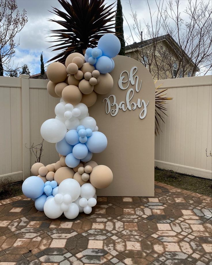 a sign with balloons attached to it in front of a fenced in area that says el baby