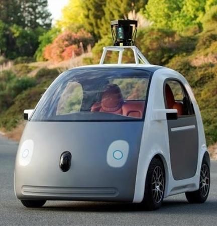 an electric car driving down the road with two people in it's back seat