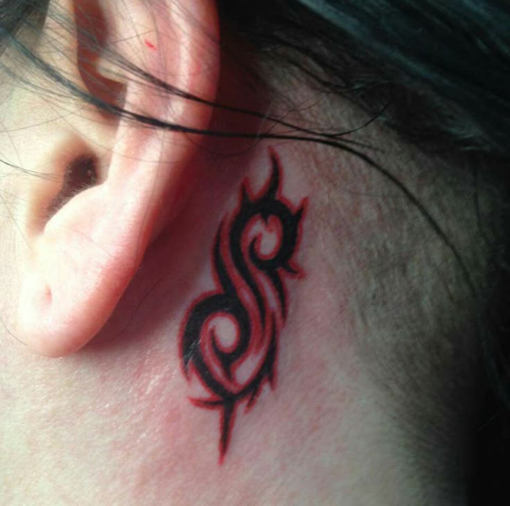 a close up of a person's ear with a tattoo design on the side