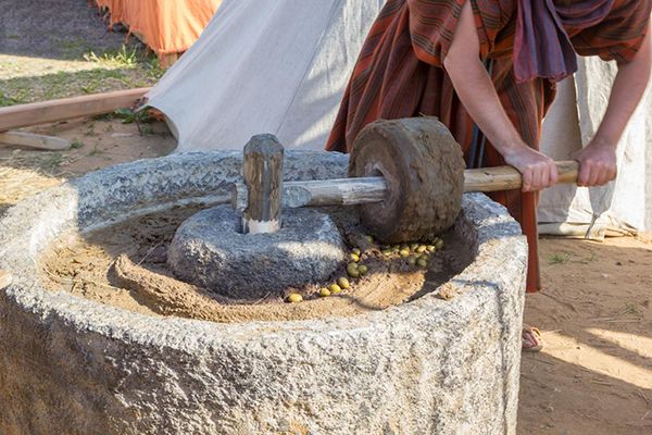 a man is working on an old stone grinding machine