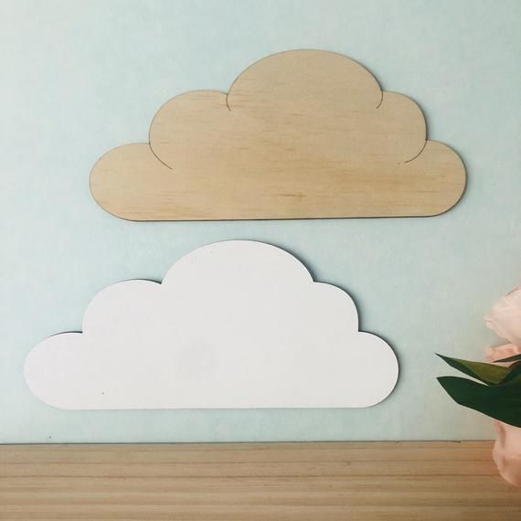 a vase with flowers sitting next to a wooden cloud