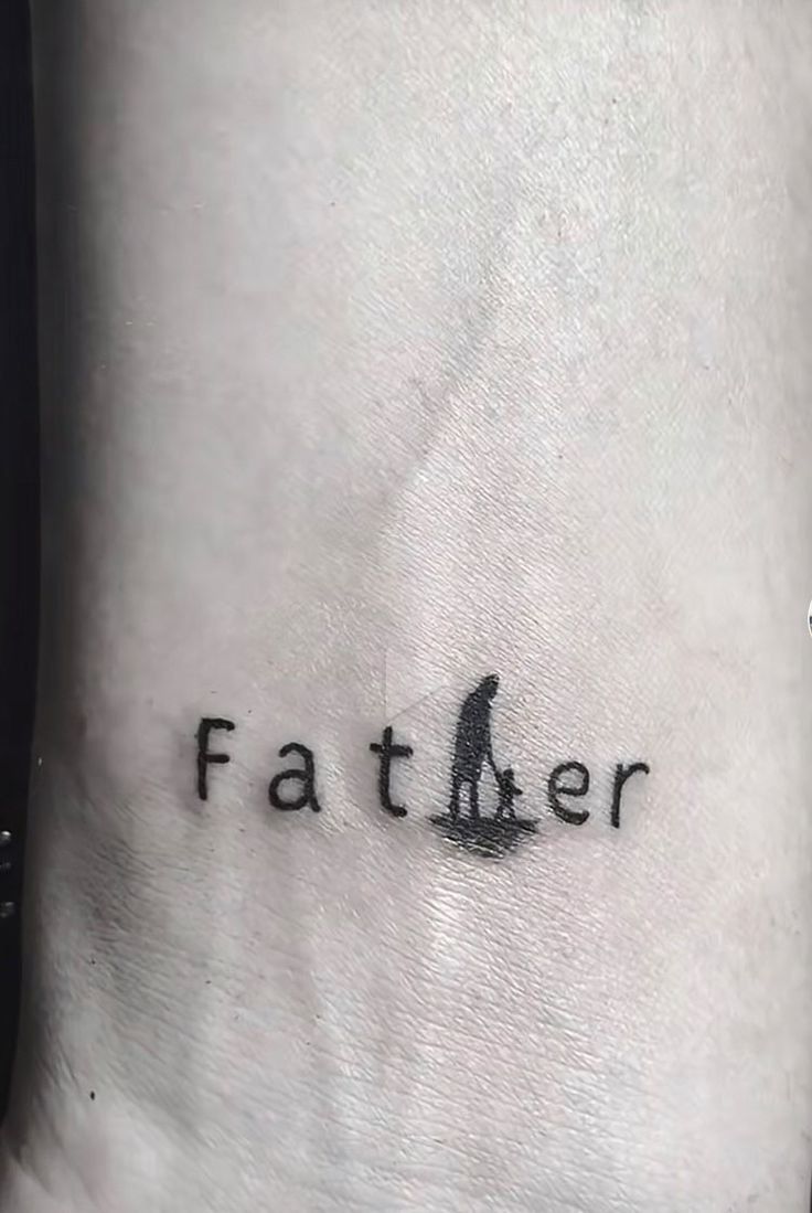 a small tattoo on the ankle that says father