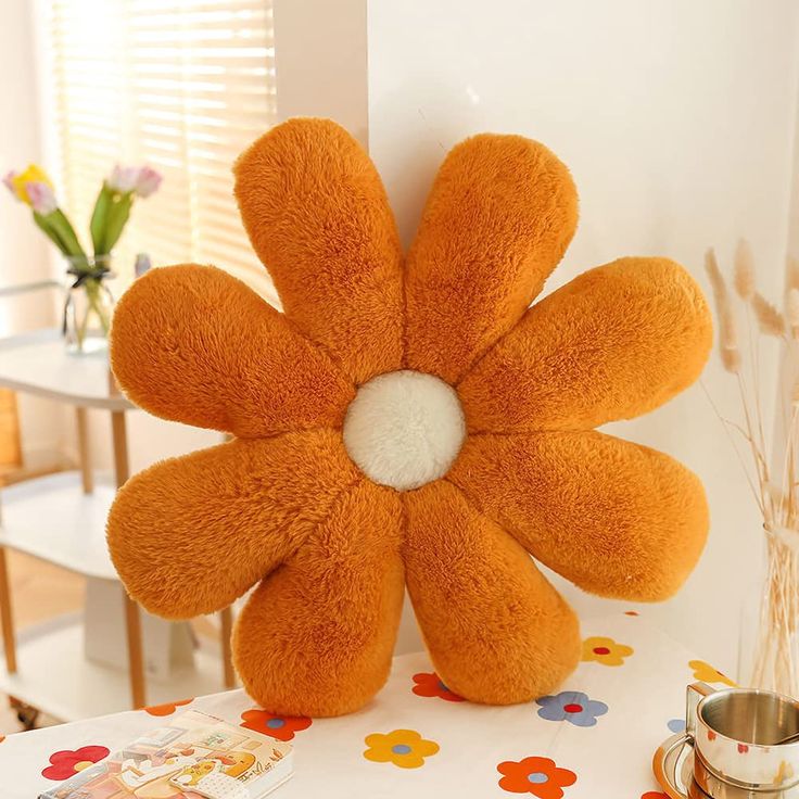 an orange flower shaped stuffed animal sitting on top of a table