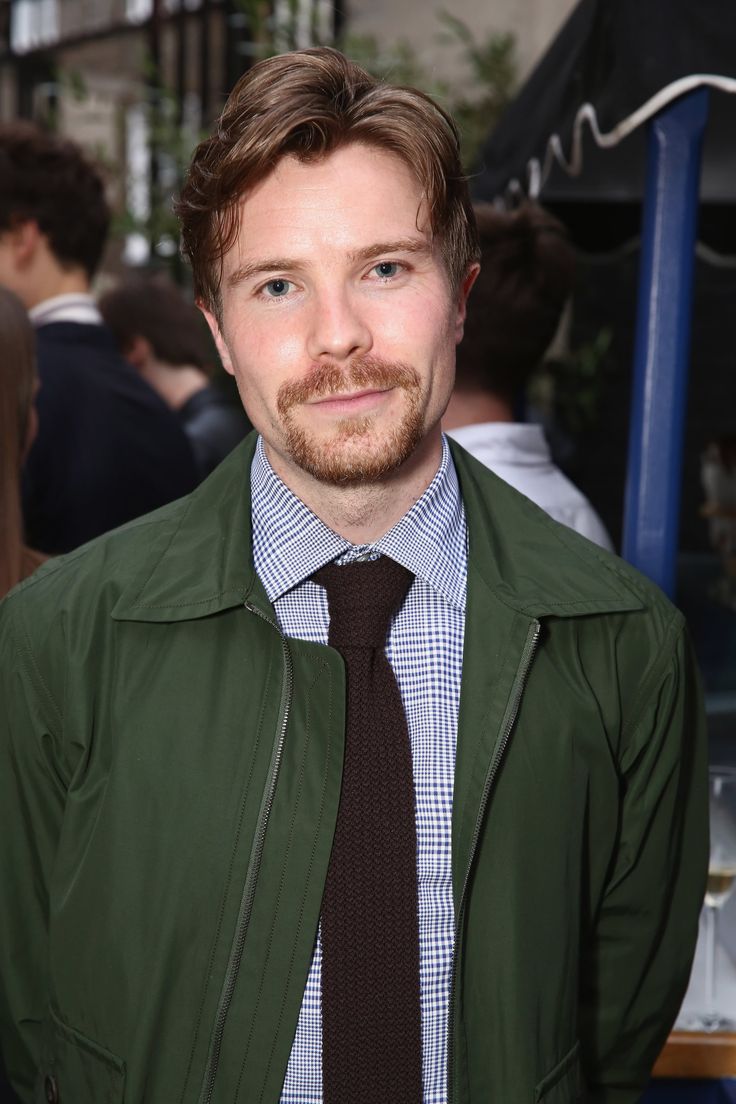 a man wearing a green jacket and tie