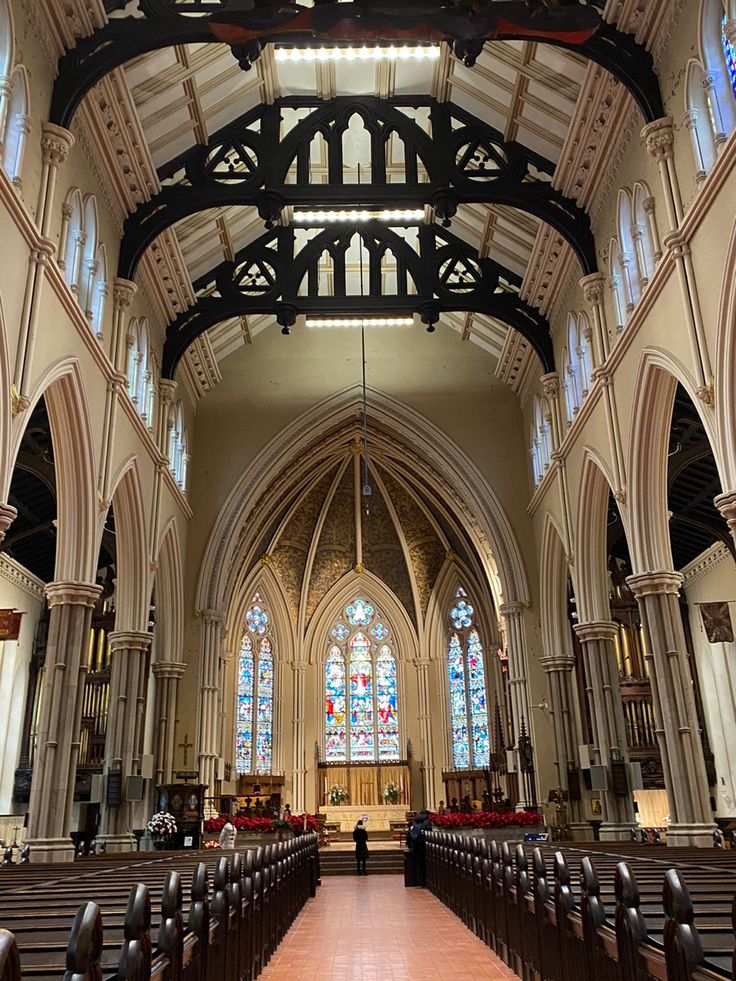 the inside of a church with pews and stained glass windows