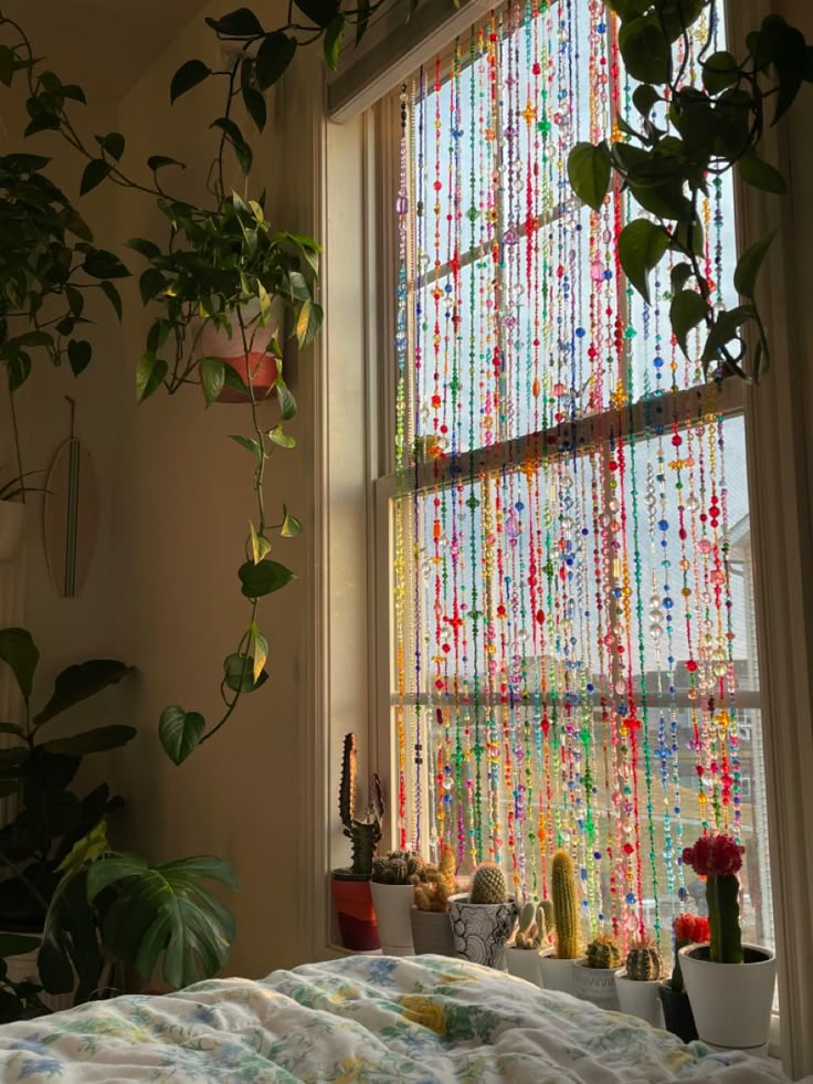 a bedroom with a bed, window and potted plants on the windows sill