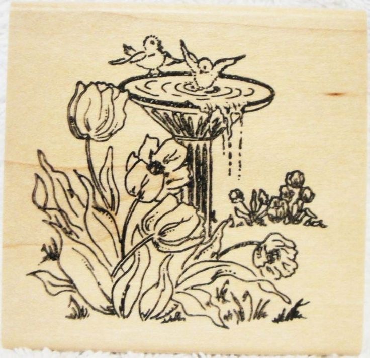 a rubber stamp with an image of flowers and birds in a fountain on the ground