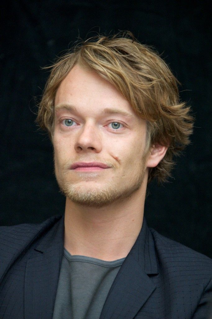 a close up of a person in a suit and tie looking at the camera with a serious look on his face