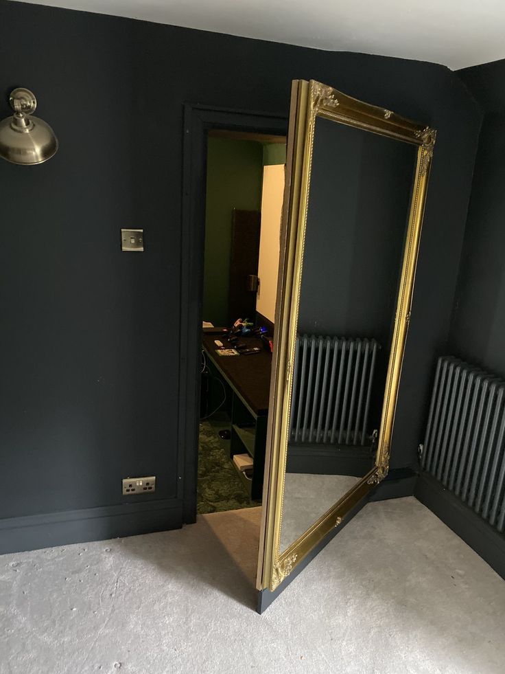 a large mirror sitting in the corner of a room next to a radiator