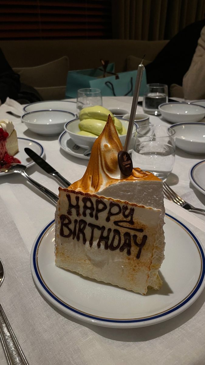 a piece of birthday cake on a plate with the words happy birthday written on it