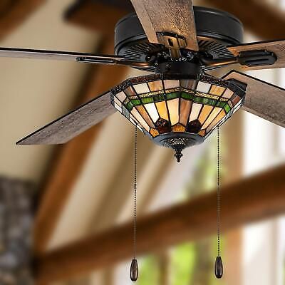 a ceiling fan with stained glass shades hanging from it's blades