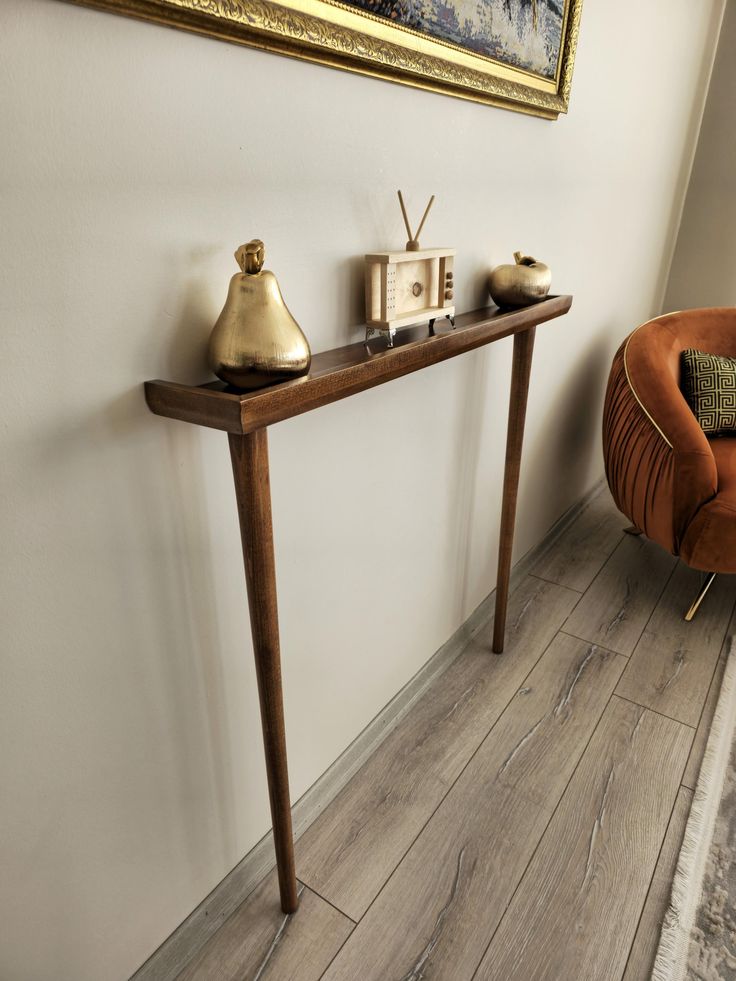 a wooden table sitting next to a brown chair on top of a hard wood floor