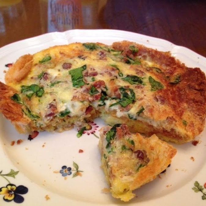 a quiche on a plate with one slice missing