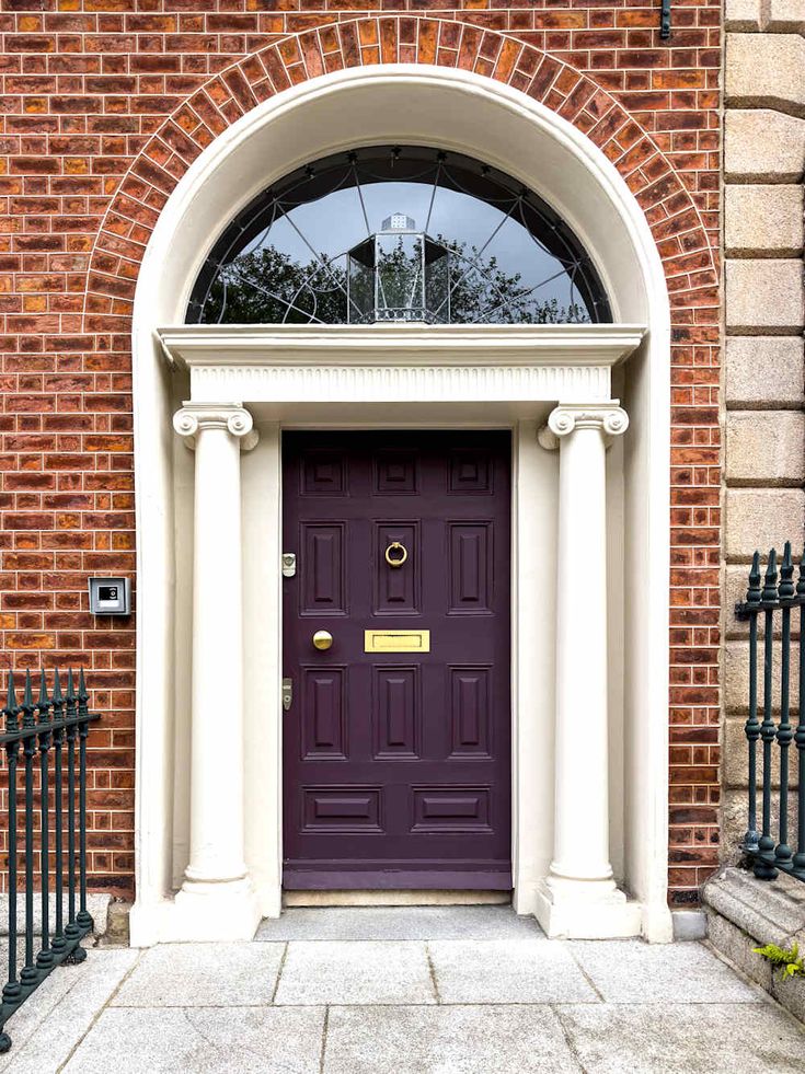 a purple door is in front of a brick building