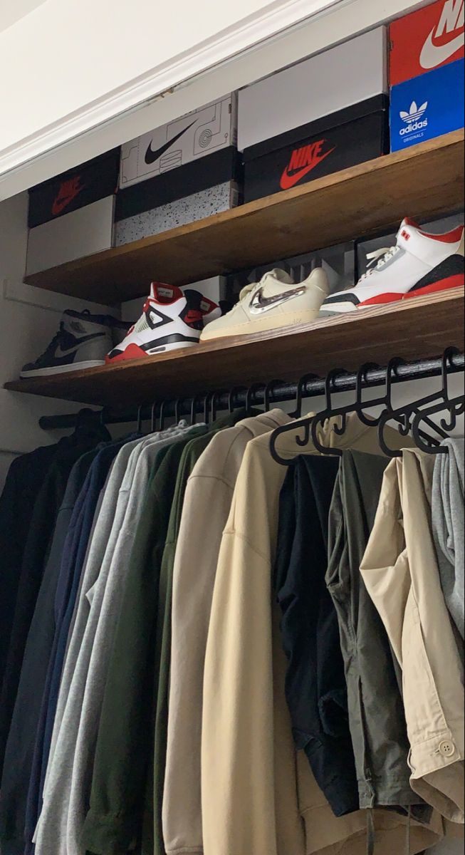 an organized closet with shoes and clothing hanging on shelves