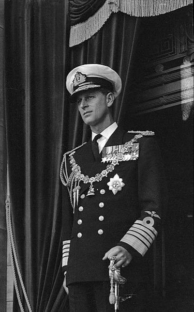 a man in uniform standing next to a curtain